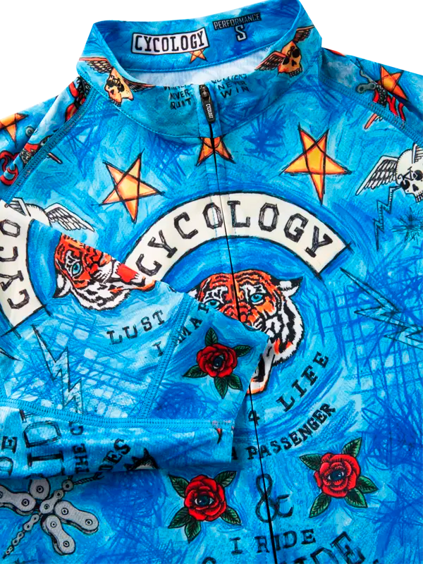 Blue cycling jersey with tattoos and text design, featuring the brand 'Cycology'.