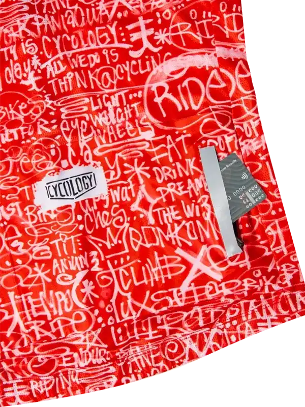 Red cycling jersey with white graffiti-style text and 'Cycology' logo, featuring bold designs for riders.
