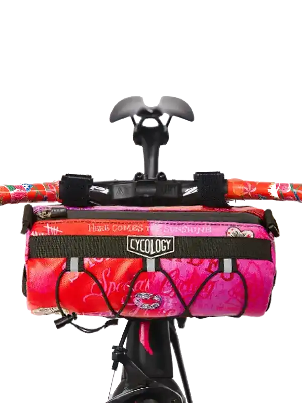 Cycology handlebar bag with pink floral design, attached to bike handlebars for cycling storage