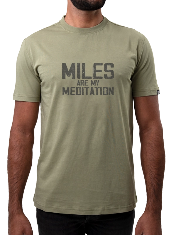 Person wearing a green t-shirt with 'MILES ARE MY MEDITATION' text 