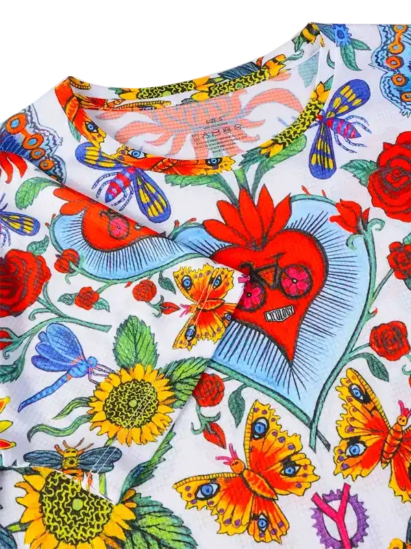 Colorful cycling jersey with butterflies, sunflowers, and heart design on white fabric