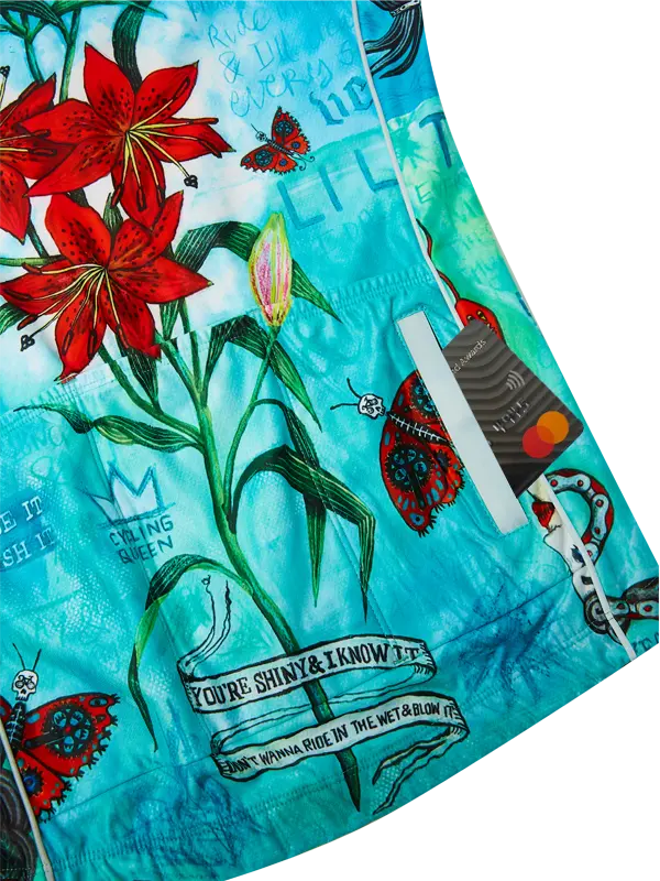 Close-up of a fabric with floral and tattoo-style designs on a blue background.