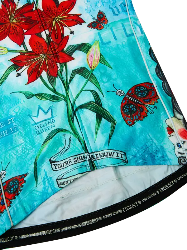 Close-up of a fabric with floral and text design, featuring red flowers and turquoise background.