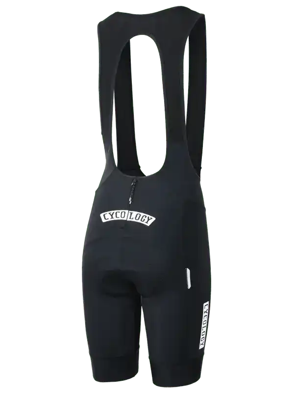 Black men's cycling bib shorts with white 'CYCOLOGY' logo, padded seat, and reflective details for road biking.