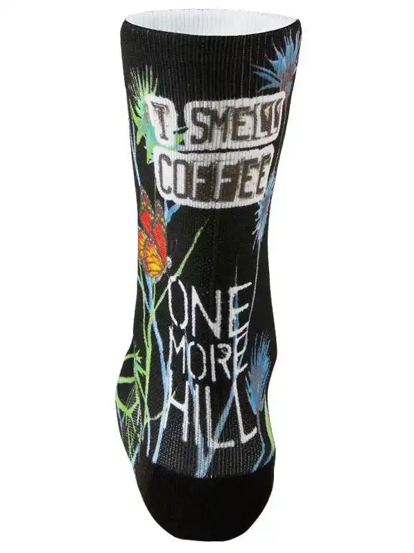 Black cycling sock with 'I Smell Coffee One More Hill' graphic, colorful butterflies, and floral designs