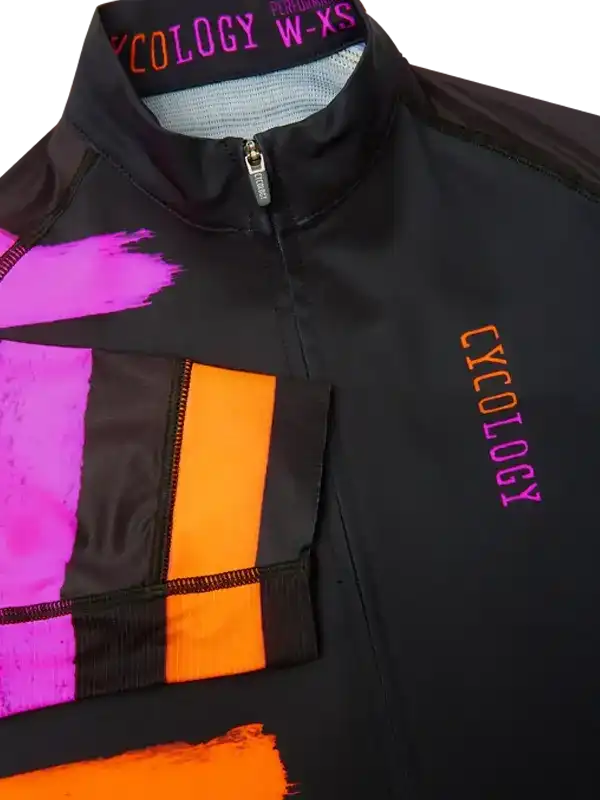 Women's black cycling jersey with bold pink and orange graphic design, zippered front, and brand logo.
