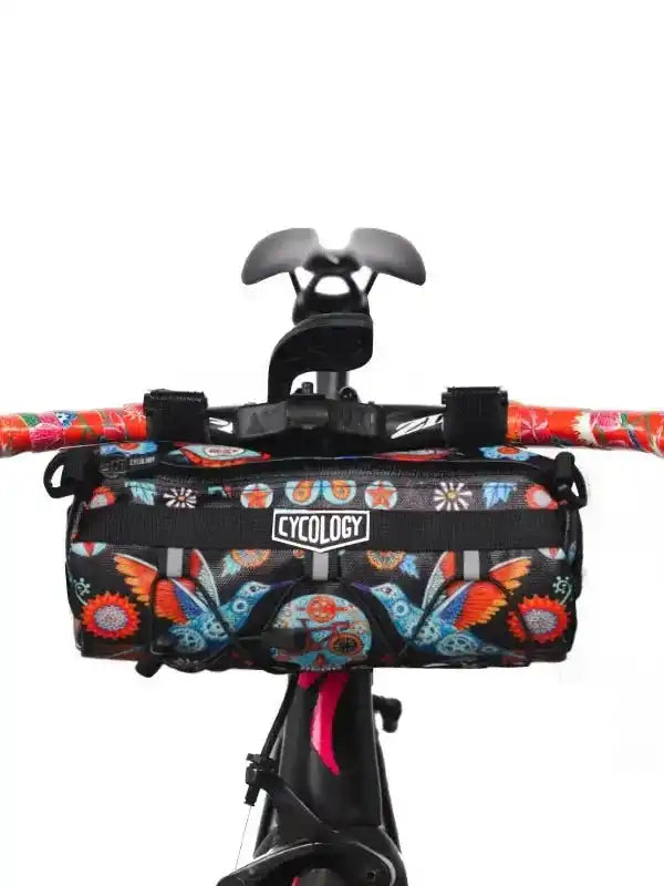 Colorful butterfly-patterned bike frame bag with Cycology logo, mounted on handlebars for cycling gear storage