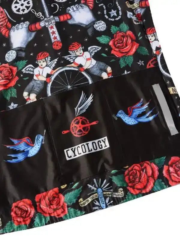 Cycling jersey with tattoo-style roses, angels, and birds on black fabric, featuring rear pockets and reflective details.