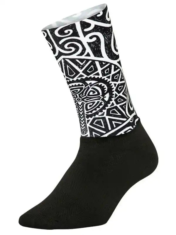 Black cycling sock with bold white tribal and geometric patterns, designed for comfort and style on rides.
