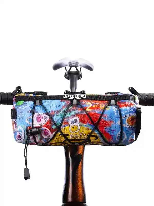 Colorful cycling handlebar bag with graffiti art, mounted on bike, ideal for road rides and commuting.