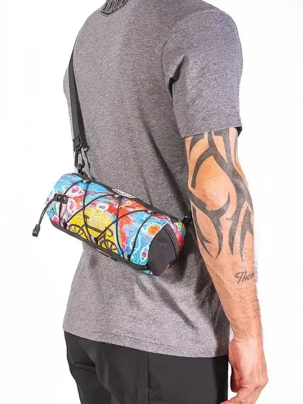Colorful patterned cycling waist bag worn by man with tattooed arm, ideal for bike rides and outdoor adventures.