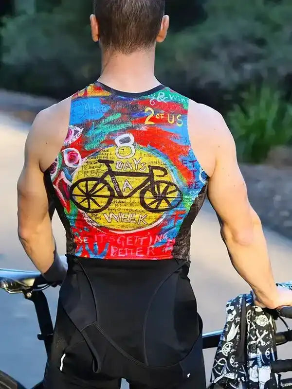 Man wearing colorful cycling jersey with '8 Days a Week' bike graphic, standing with road bike outdoors