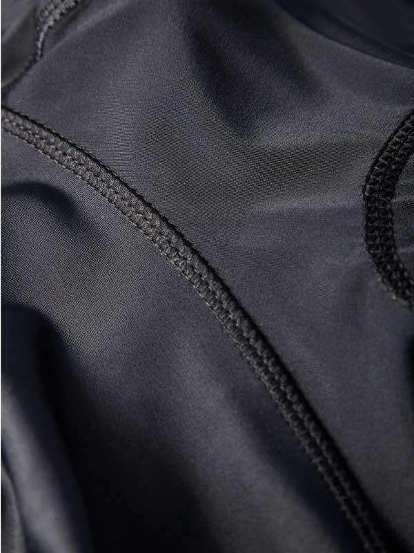 Close-up of black cycling jersey fabric with detailed stitching and breathable mesh panel