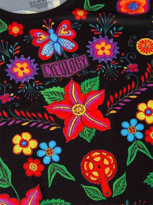 Vibrant floral and butterfly print cycling jersey with bold colors and bike gear motif on black fabric