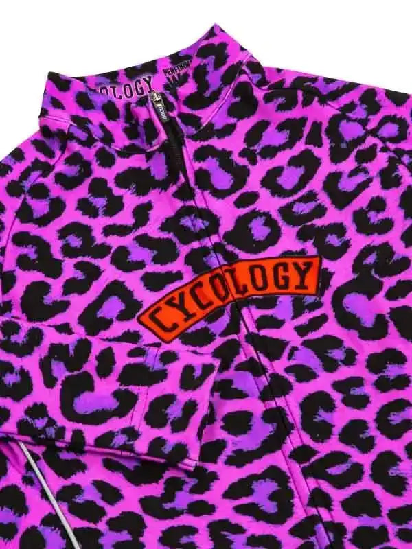 Vibrant pink and purple leopard print cycling jersey with bold 'CYCOLOGY' logo, perfect for women's bike wear.