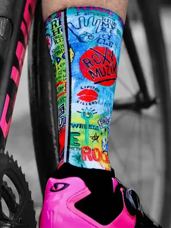 Colorful cycling socks with bold graphic designs, paired with pink cycling shoes and bike frame