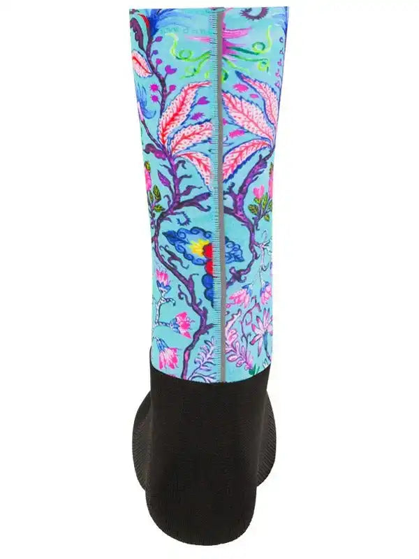 Vibrant floral cycling leg warmer with colorful botanical print on light blue background