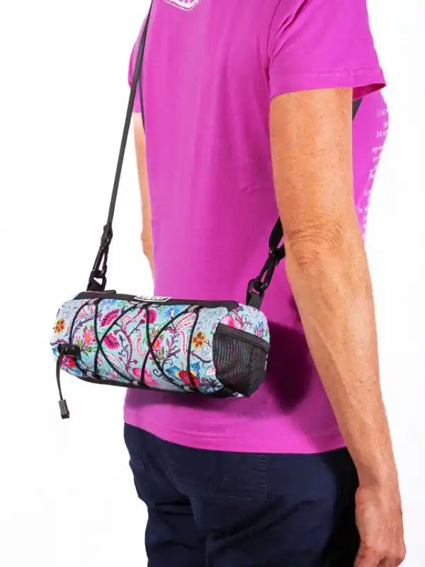 Colorful floral cycling waist bag with mesh pocket, worn crossbody by cyclist in pink shirt