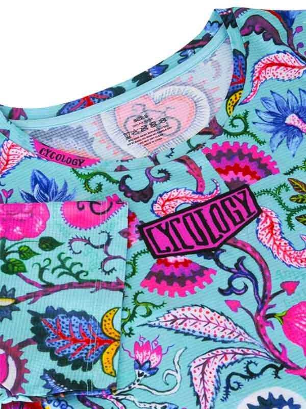 Vibrant floral cycling jersey with bold pink Cycology logo, featuring unique patterned design for women's bike wear.