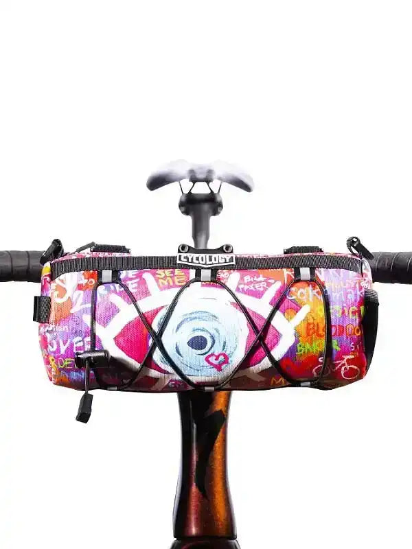 Colorful graffiti-style bike frame bag with heart and eye design, mounted on handlebars for cycling gear storage