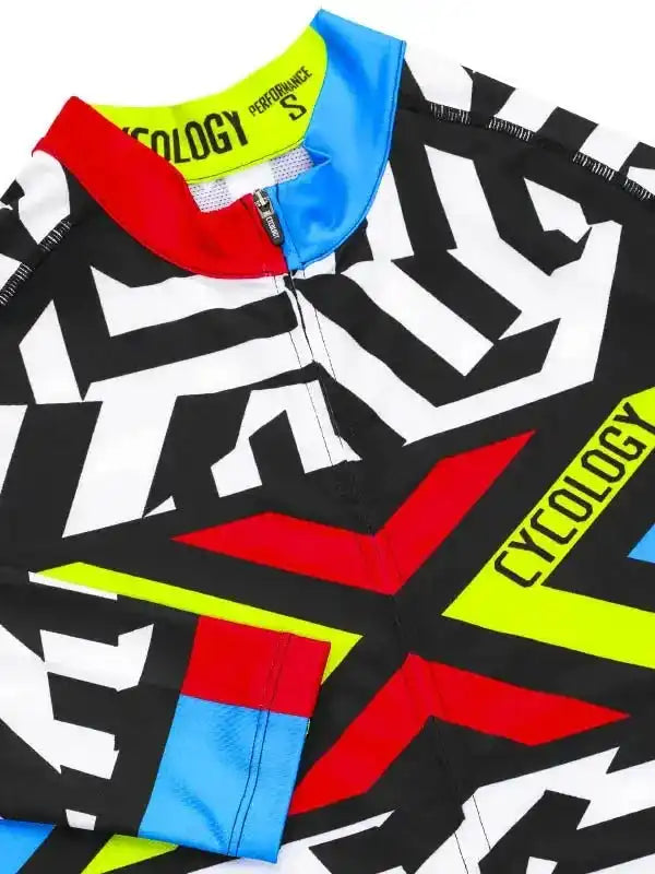 Men's cycling jersey with bold black, white, red, and neon yellow geometric design, featuring performance fabric and zipper detail.