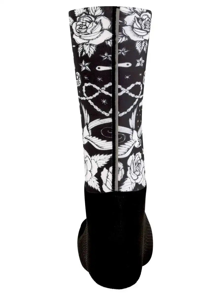 Black cycling sock with white rose, chain, and star tattoo-style print, high-quality fabric design