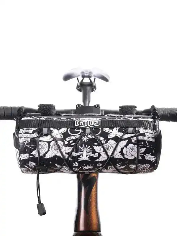 Black and white tattoo-style cycling frame bag with roses and wings, mounted on bike handlebars