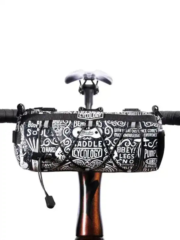 Black and white patterned cycling handlebar bag with bold text designs, mounted on bike frame